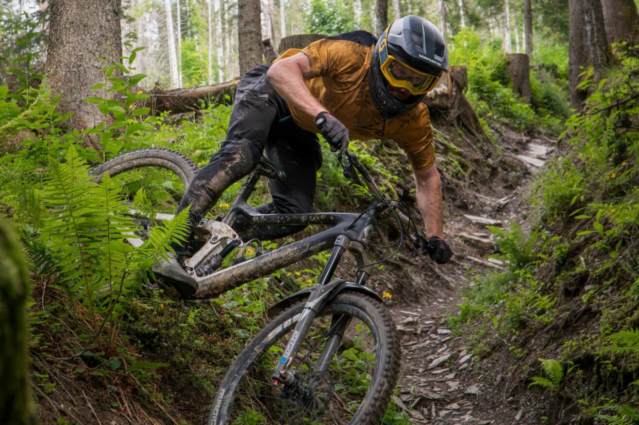 Mountain bike rider cycling downhill on trails.